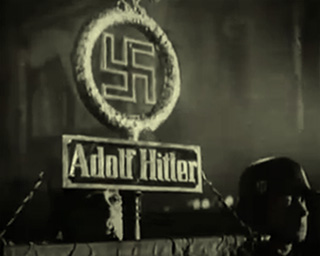 SS soldiers holding aloft a Nazi Adolf Hitler banner during a night parade, in the lead up to World War Two in 1938.